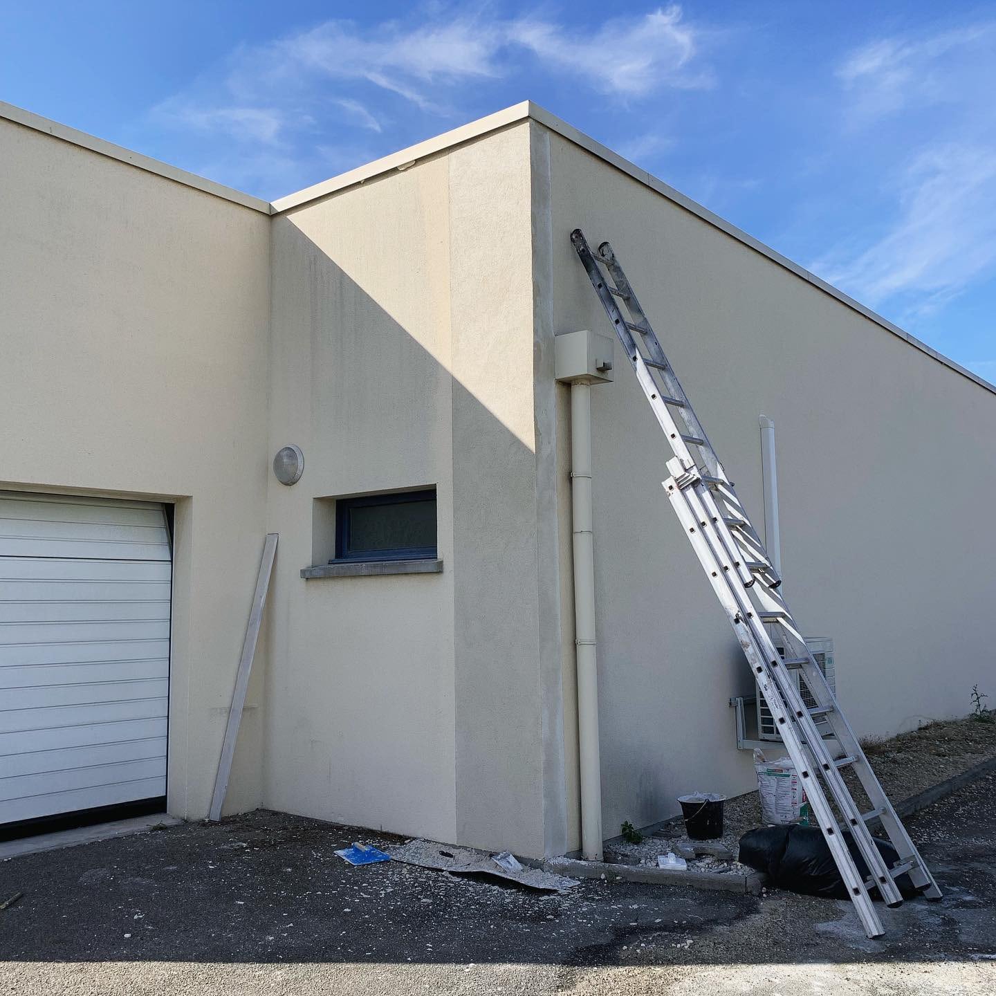 Façade latérale de la clinique vétérinaire à Pithiviers pendant la rénovation avec échelle et travaux de maçonnerie