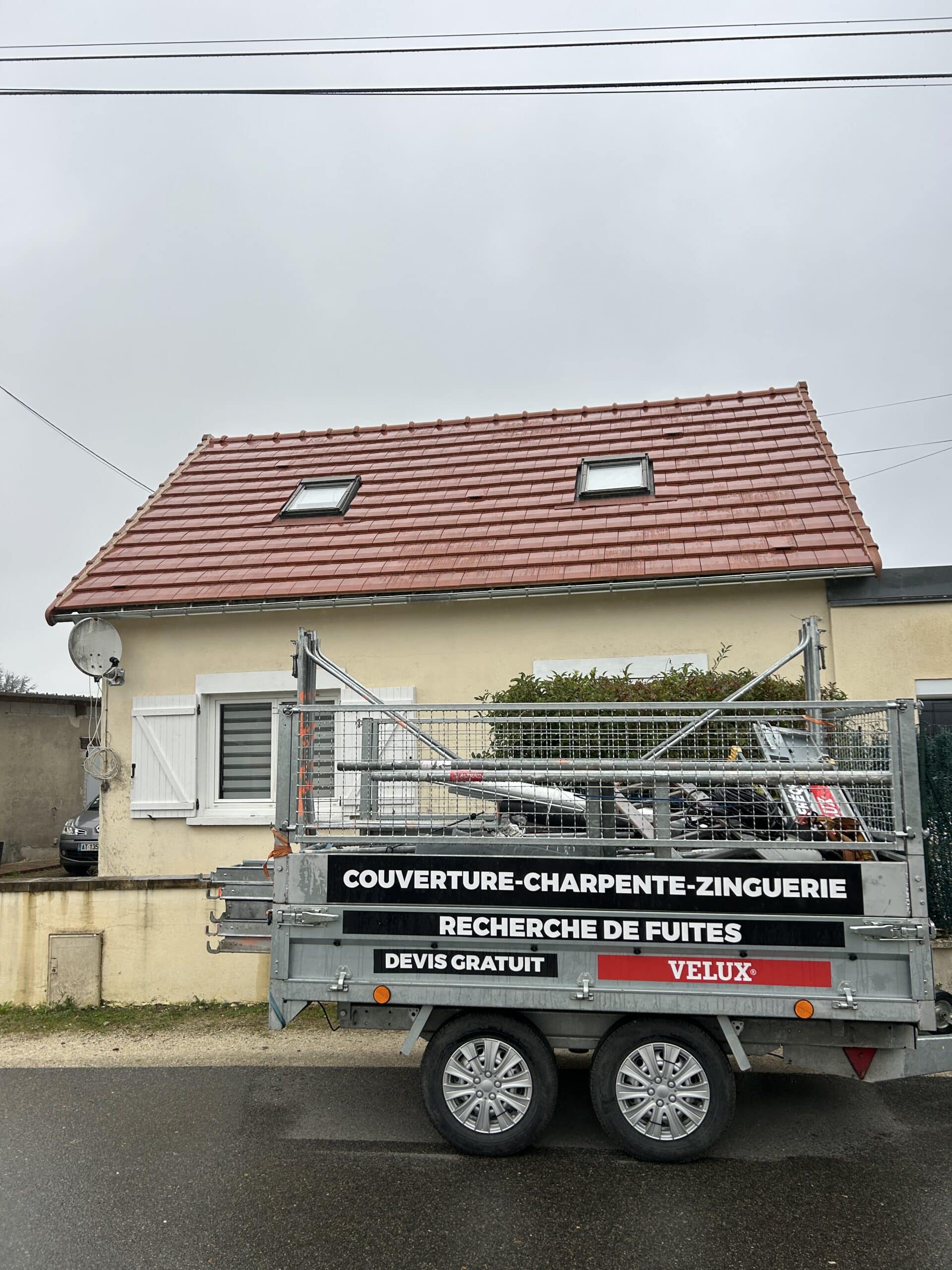Bande-annonce d'entreprise pour toiture et zinguerie avec logo VELUX devant une maison au toit de tuiles rouges et lucarnes.